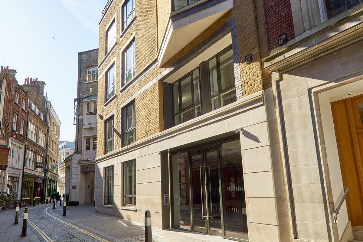 Modern stone facade and glass entrance of the 69 Carter Lane building on a historic London street.