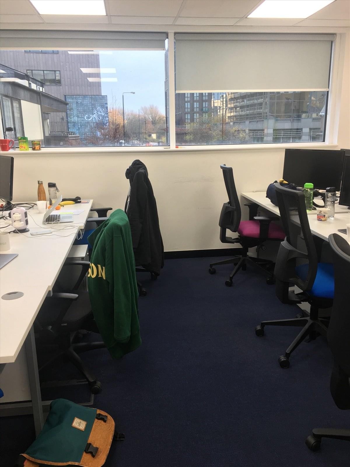 Open-plan office at Tower Bridge Business Centre with workstations, ergonomic chairs, and large windows.