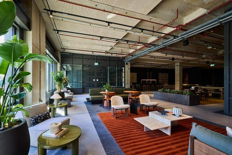 Spacious communal lounge at Three Deal Porters, Deal Porters Way with diverse seating, plants, and industrial ceilings.