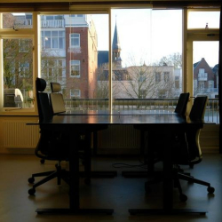Meeting room featuring a long dark table and a large window overlooking the city skyline.