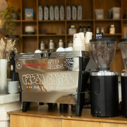 Professional espresso machine at the in-house cafe featuring chalk-style artwork.