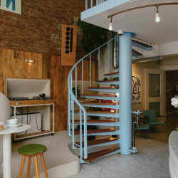 Interior view of a light blue spiral staircase connecting office levels.