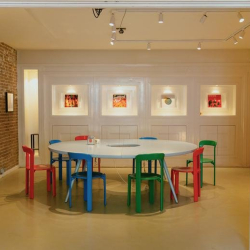 Creative meeting space with a large circular table and vibrant, multi-colored chairs.