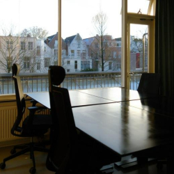 Desk stations situated next to a large window offering views of local canal houses.