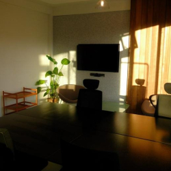 Dark-toned meeting space with a long table and dramatic golden hour lighting.