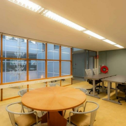 Office space with a round table and ergonomic desk chairs.