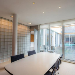 Bright conference room with a glass wall and modern lighting.