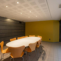 Oval table in a compact meeting room with wooden chairs.
