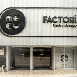 Modern entrance to the business center with black circular branding and sliding doors.