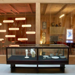 Lobby view through glass featuring a display case and creative lighting.