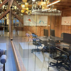 Spacious office interior featuring a wooden staircase and glass partitions.