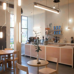 Modern café area with a wooden counter and small tables.