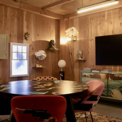 Eclectic meeting room with a round table and colorful patterned chairs.