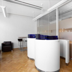Stylish reception area with curved white desks and glass wall dividers.