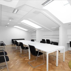 Large open-plan attic workspace with multiple desks and bright skylights.