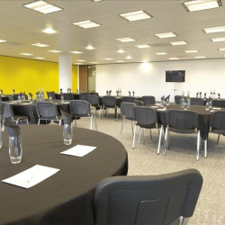 Expansive event space with several round tables and yellow feature wall, One Kingdom Street, London, W2.