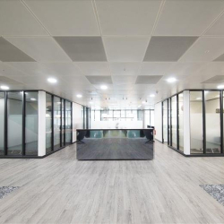 Symmetrical view of a sleek reception desk and modern glass-walled offices, One Kingdom Street, London, W2.