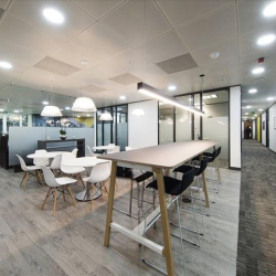 Shared breakout space with communal kitchen, high tables, and contemporary design, One Kingdom Street, London, W2.