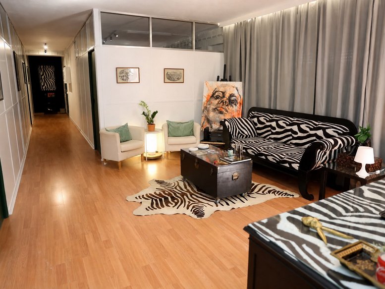Spacious communal lounge at Tv. do Conde da Ponte 10 1 Esq, with zebra-print furniture and warm lighting.