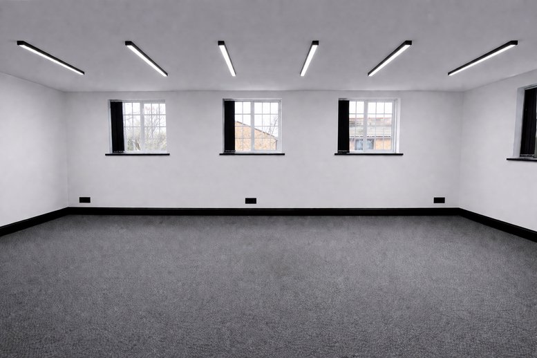 Spacious office interior at Unit 7, Mowat Industrial Estate Road with three windows and grey carpeting.