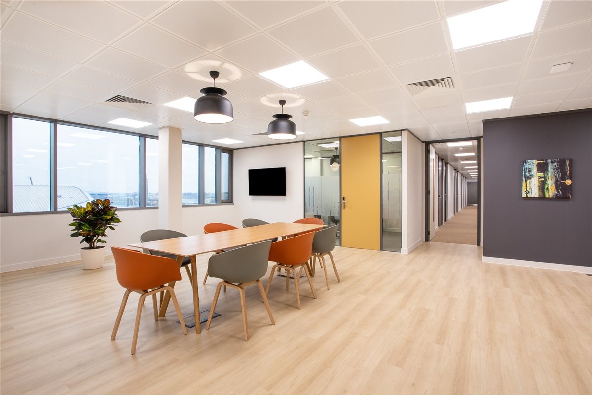 Spacious boardroom at Via Battaglione Framarin N.20 with orange chairs and city views.