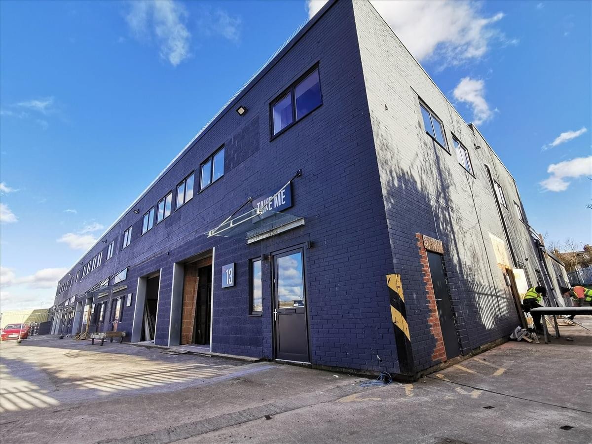 Exterior view of the dark blue facade at Gosforth Industrial Estate with loading bay entrances.