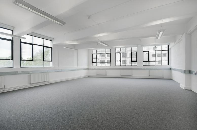 Spacious open-plan office space with grey carpeting and large windows at Parma House, Clarendon Road.