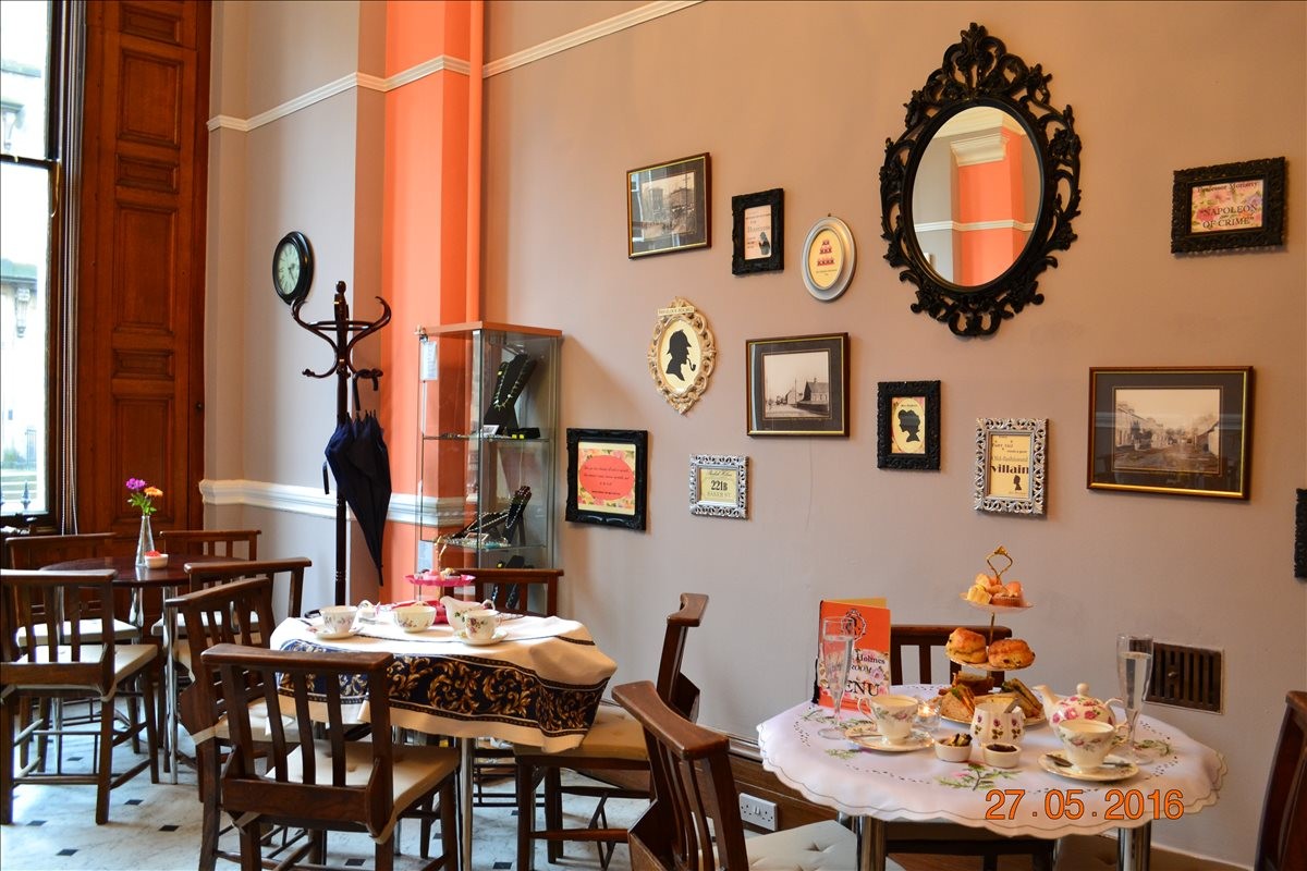 The ornate tea room at Sir Arthur Conan Doyle Centre with framed wall art and vintage decor.