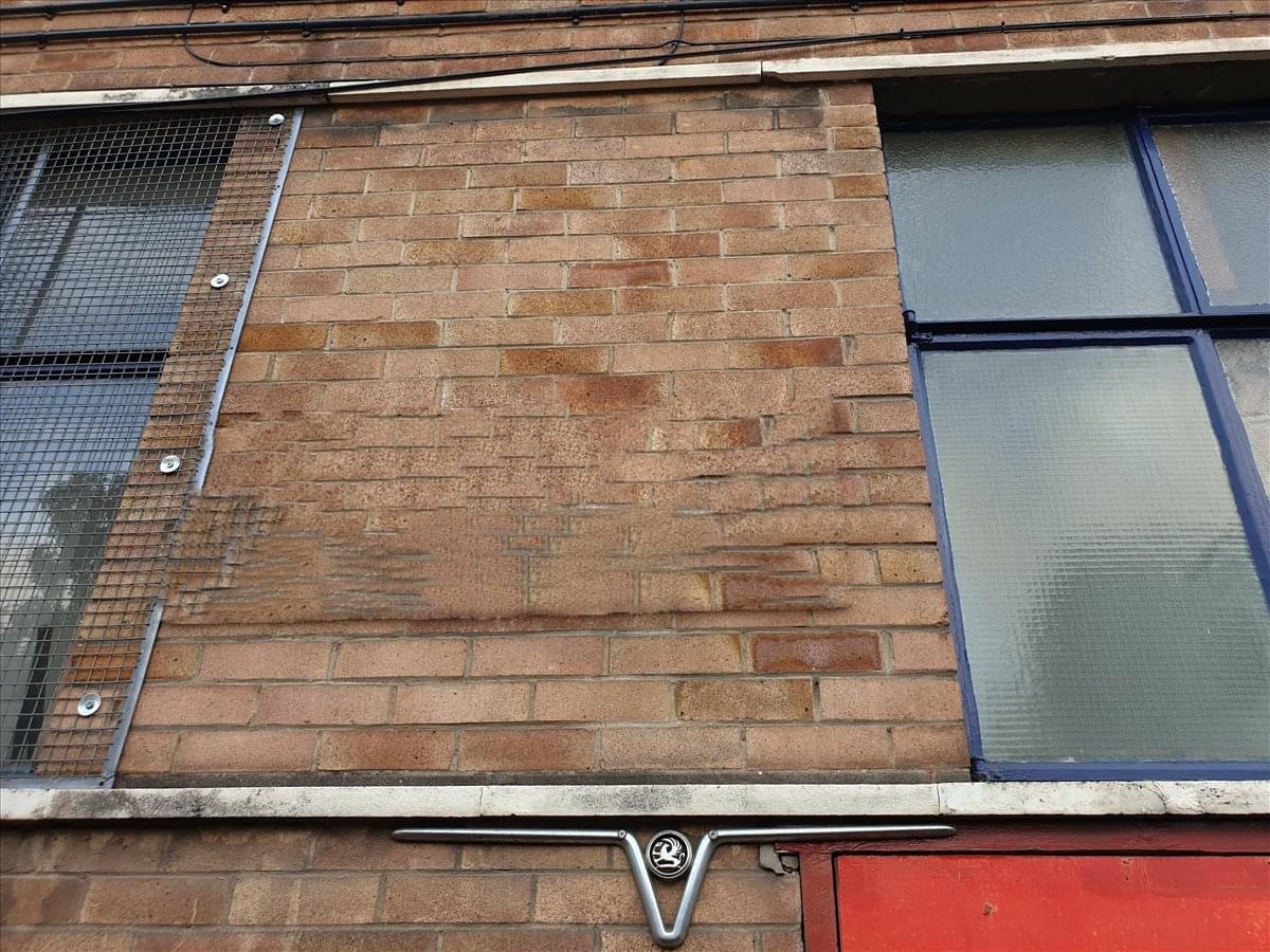 Exterior brick facade of 54-56 Brigstocke Road, Bristol with industrial windows and metal accents.