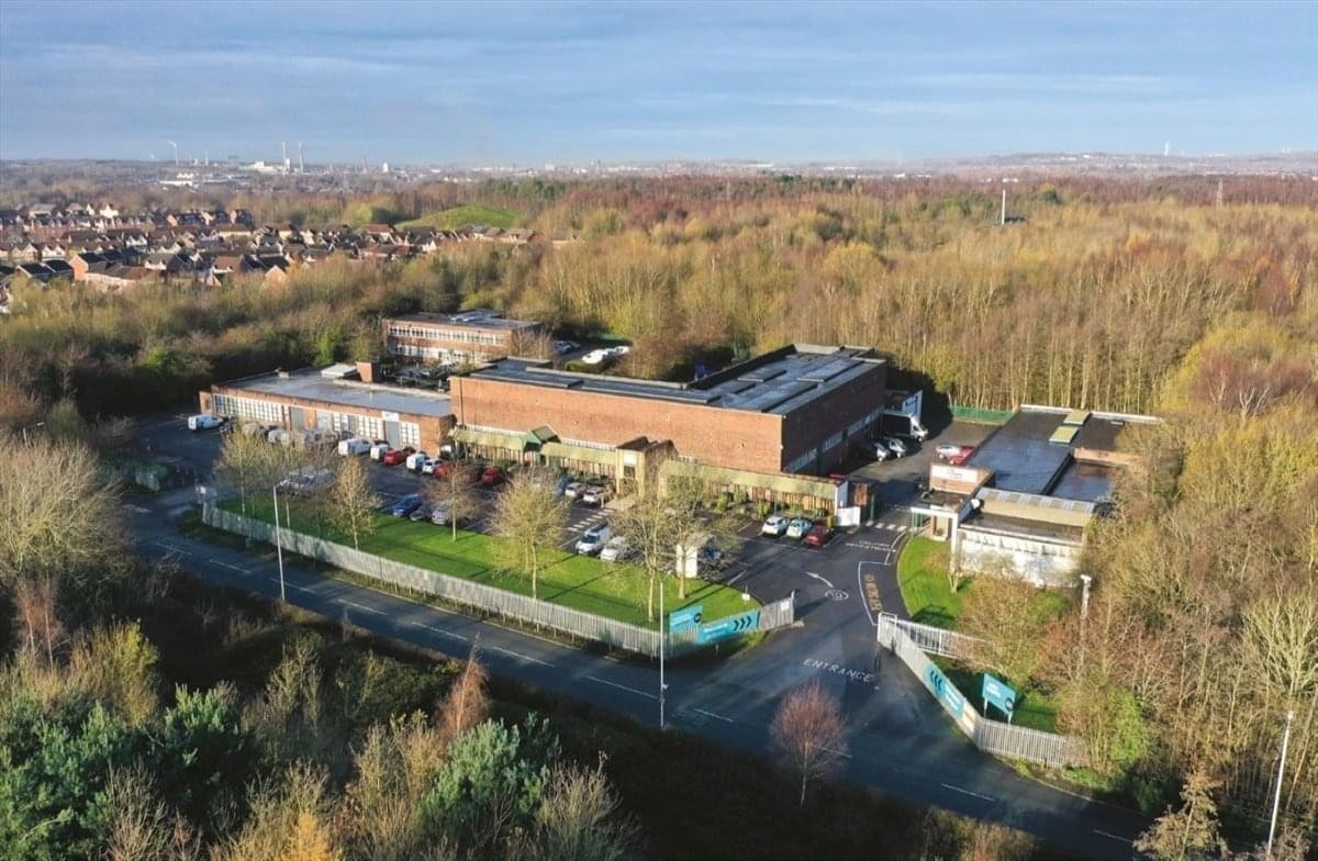 High-angle aerial shot of Bold Business Centre surrounded by lush green trees and local housing.