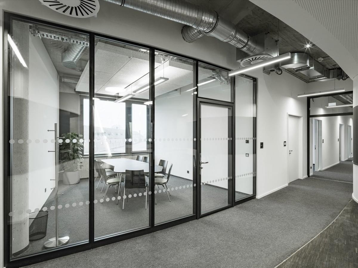 A modern glass-partitioned meeting room at Carl-Friedrich-Gauß-Ring 5, BDC Coworking, Heidelberg.