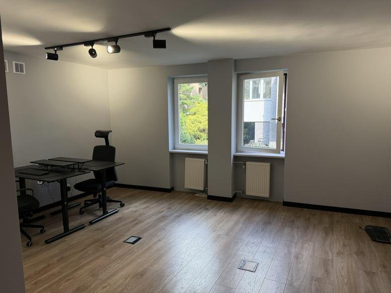 Spacious private office at Zamkowa 19/26 with dual workstations and natural light from two windows.